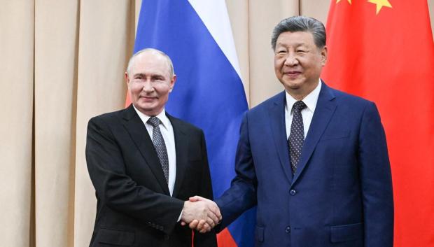 El presidente de Rusia, Vladímir Putin, y el presidente de China, Xi Jinping, se estrechan la mano