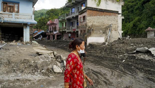 Una mujer camina este lunes por una zona afectada por una riada en Devighat (Nepal)