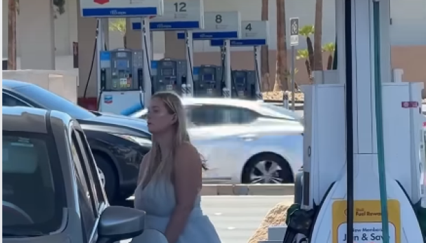 La conductora vigila mientras llena su coche