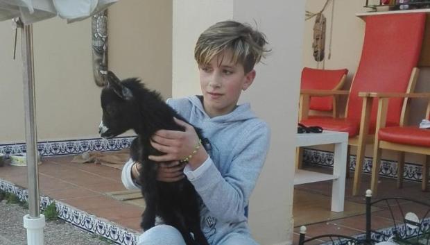 David, con 12 años, sujeta en sus brazos a su primera cabra