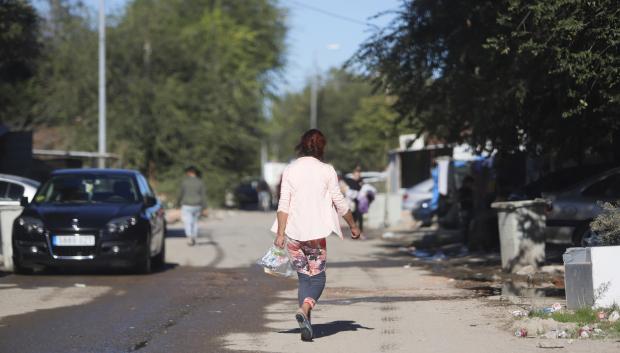 Una mujer caminando dirección a la salida del Sector 6 de la Cañada Real