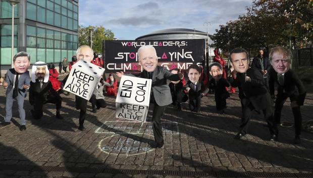 Varios manifestantes ecologistas portan caretas de los líderes mundiales