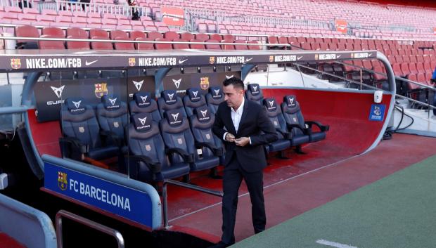 El nuevo entrenador del FC Barcelona, Xavi Hernández, posa en el banquillo del Camp Nou