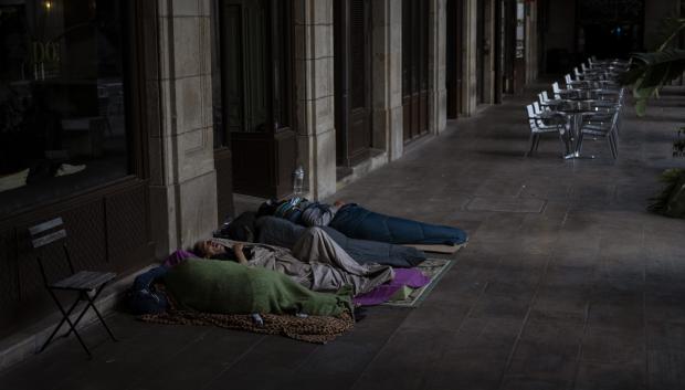Un grupo de personas sin hogar duermen en una calle de Barcelona