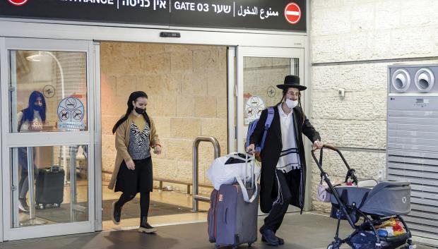 Arriving passengers inbound from Kyiv walk with their luggage at Israel's Ben Gurion airport in Lod near Tel Aviv on February 13, 2022. (Photo by JACK GUEZ / AFP)