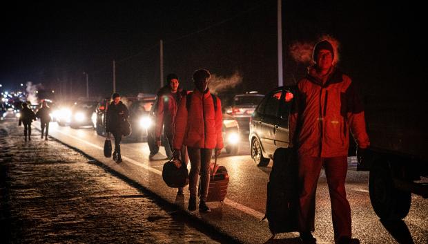 Personas a pie y en automóviles se mueven para cruzar de Ucrania a Polonia en el cruce fronterizo de Korczowa-Krakovets el 26 de febrero de 2022.