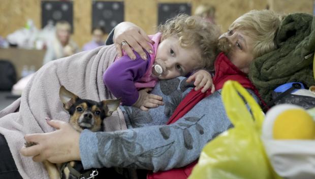 Una mujer sostiene a un niño y a un perro en un refugio en Mariúpol, Ucrania