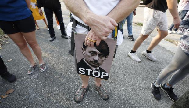 Un manifestante sujeta en Bangkok una fotografía en la que se superpone la imagen de Putin y la de Hitler durante una manifestación contra la invasión rusa de Ucrania