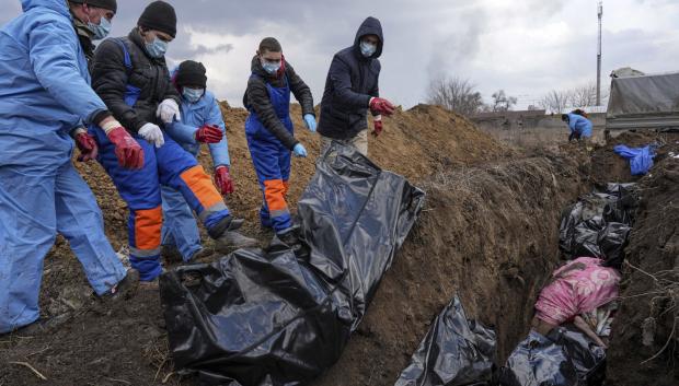 Los cadáveres son colocados en una fosa común en las afueras de Mariúpol (Ucrania)