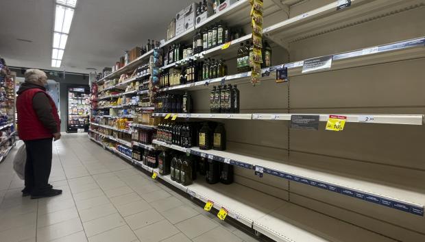 Un hombre observa unas estanterías vacías de aceite en un supermercado de Madrid este sábado