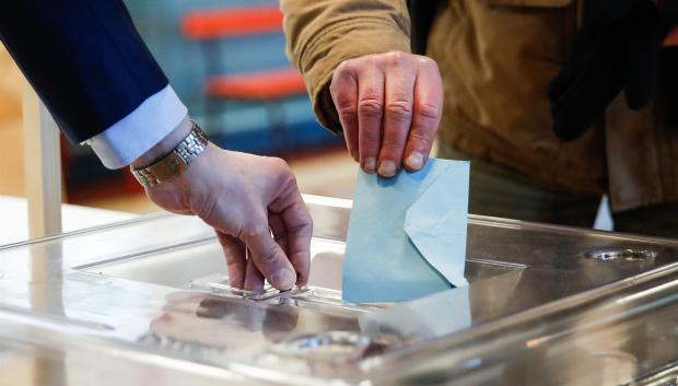 Un hombre deposita su voto en una urna durante la primera vuelta de las elecciones presidenciales de 2022 en Francia