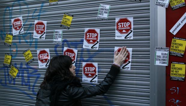 Una mujer coloca pegatinas durante una protesta contra el desempleo entre los jóvenes en abril de 2013