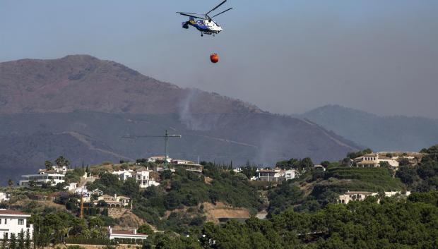 Un helicóptero sigue trabajando en la extinción del incendio forestal de Pujerra (Málaga). El incendio ya está estabilizado