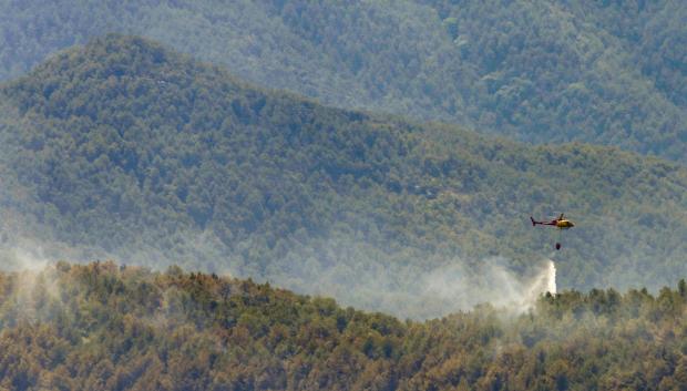 Un helicóptero de los bomberos de la Generalitat, suelta agua en el incendio de LLadurs