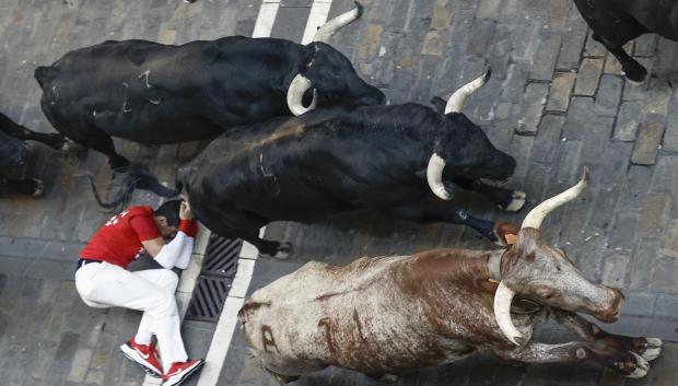 Los mozos corren durante el séptimo encierro de los Sanfermines ante los toros de la ganadería de Victoriano del Río Cortés