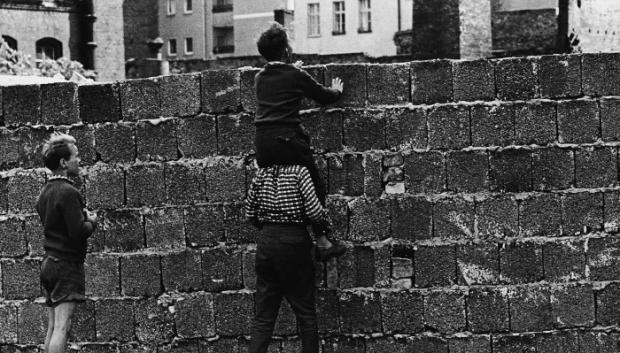 Niños del oeste de Berlín mirando por encima del Muro