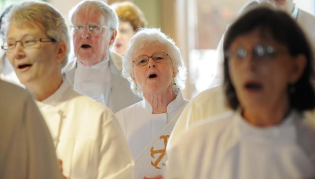 Maria McClain, middle, sings with others before entering the sanctuary of the Freiden's United Church of Christ in Indianapolis, April 15, 2012.