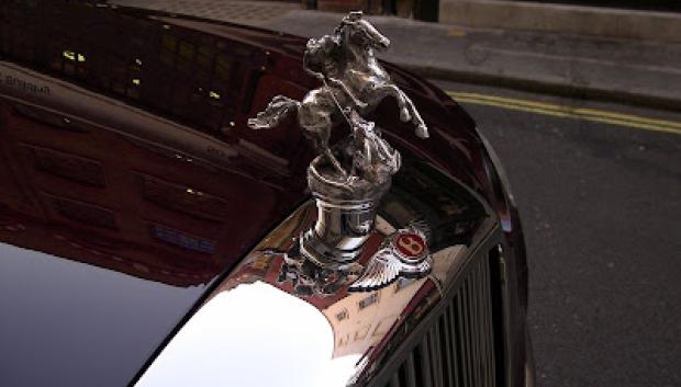 Detalle del emblema personal de la Reina Madre y además patrón de Inglaterra, San Jorge luchando con el dragón sobre el capó del Bentley