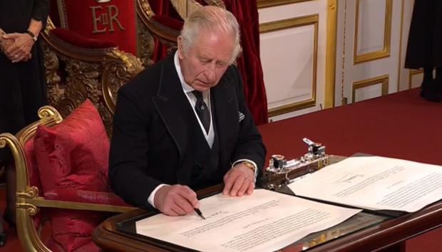 Carlos III durante la firma oficial de su coronación