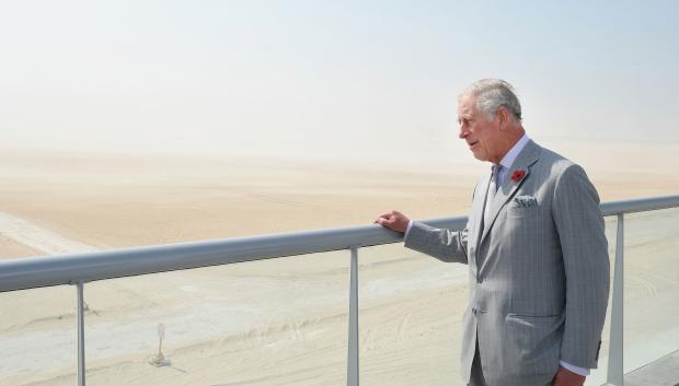 The Prince of Wales looks at the site of the Expo 2020, from the elevated offices in the desert in Dubai.