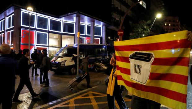 Un manifestante exhibe una bandera de Cataluña con una urna estampada