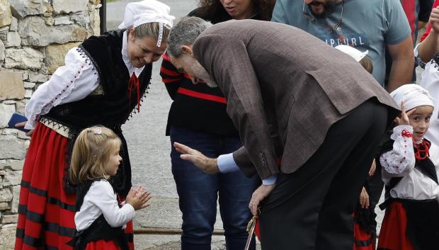 El Rey Felipe VI saluda a una pequeña durante la visita de los miembros de la familia real a la parroquia de Cadavedo