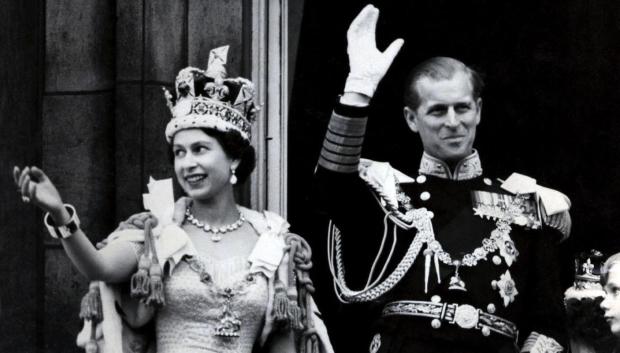 Queen Elizabeth II wearing the Imperial State Crown, and the Duke of Edinburgh, in the uniform of Admiral of the Fleet, waving from the balcony of Buckingham Palace after the Queen's Coronation.
File photo dated 02/06/1953 of