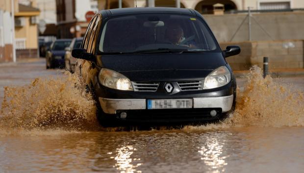 Un vecino del municipio de San Pedro del Pinatar, intenta avanzar con su coche por una de las calles inundadas por el paso de la borrasca Gloria, en Murcia