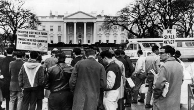 Un grupo de personas se manifiesta a favor de la paz y contra la guerra de Vietnam frente al edificio de la Casa Blanca, en Washington