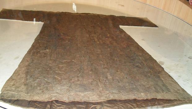 Relicario textil en forma de una túnica confeccionada con varias capas. La más interior contiene los fragmentos de la reliquia.