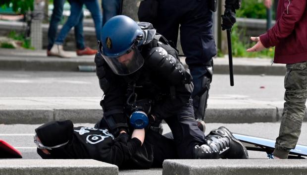 Un agente de policía detiene a uno de los manifestantes
