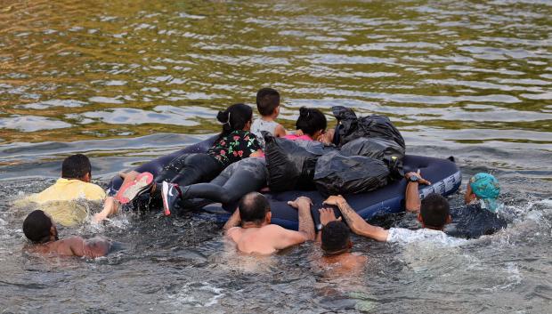 Migrant people try to get to the US through the Rio Grande as seen from Matamoros, state of Tamaulipas, Mexico, on May 11, 2023. - A surge of migrants is expected at the US-Mexico border cities as President Biden administration is officially ending its use of Title 42. On May 11, President Joe Biden's administration will lift Title 42, the strict protocol implemented by previous president Donald Trump to deny entry to migrants and expel asylum seekers based on the Covid pandemic emergency. (Photo by Alfredo ESTRELLA / AFP)