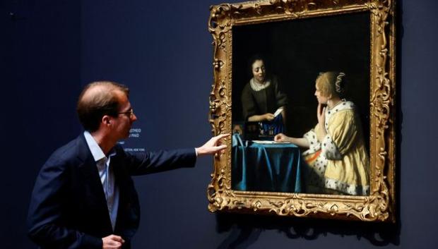 Taco Dibbits, director del Rijksmuseum de Amsterdam, muestra "Ama y criada" de Vermeer durante una exhibición