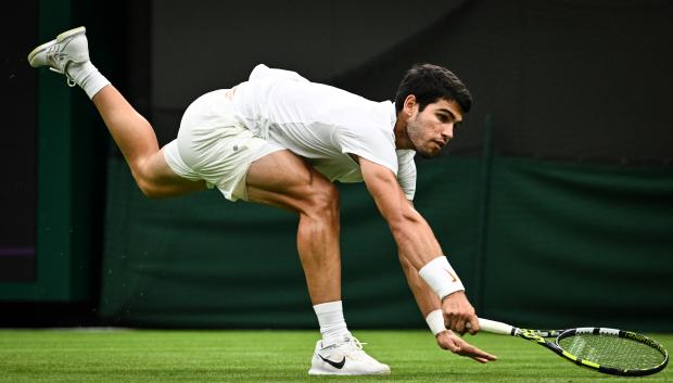 Carlos Alcaraz persigue una pelota durante su debut en Wimbledon