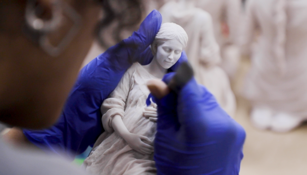 Una de las artistas retoca una réplica de la Madre de la Esperanza en el estudio