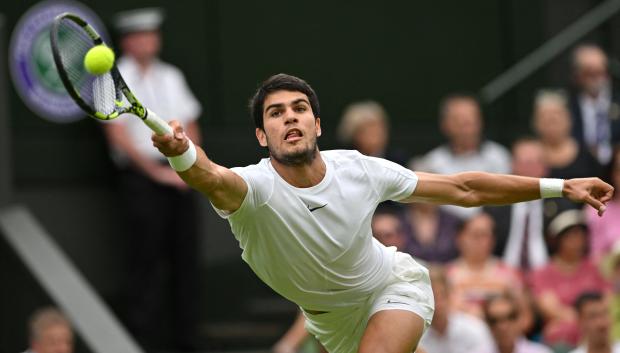 Carlos Alcaraz se estira a por una pelota en la central de Wimbledon