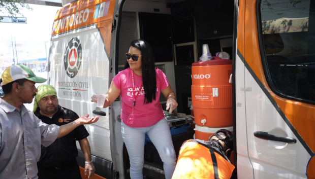 Una empleada distribuye vasos de agua mientras continúan las altas temperaturas en el estado de Nuevo León, México, 22 de junio de 2023 hora local. La red eléctrica de México está en alerta tras semanas de una ola de calor sin precedentes en todo el país