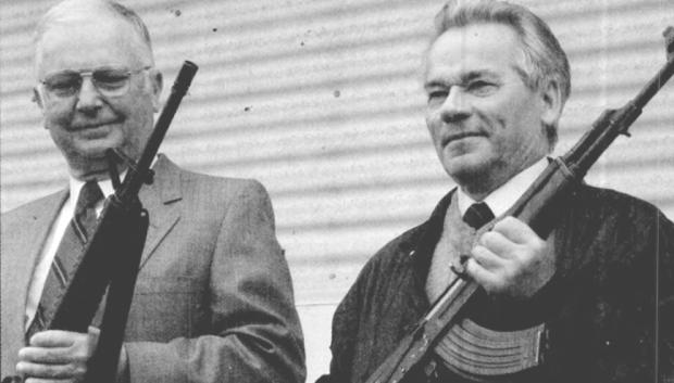 Kalashnikov (dcha.) y Eugene Stoner (izq.) sostienen los rifles que diseñaron, tomada en mayo de 1990