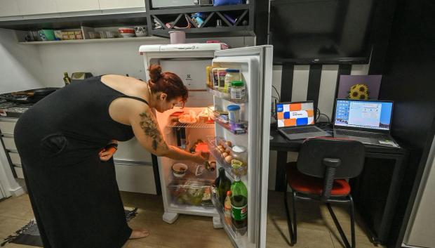 Lara Maia revisa su refrigerador en su microapartamento de 16 metros cuadrados, en el centro de Sao Paulo, Brasil
