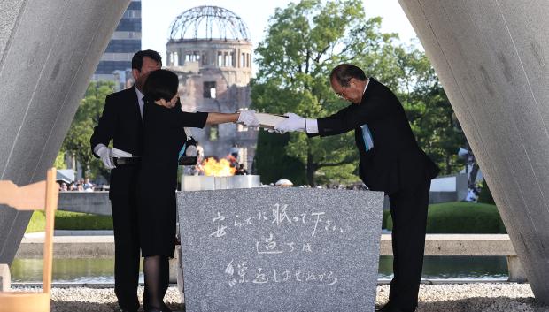 El alcalde de Hiroshima, Kazumi Matsui (D), y los representantes de las familias consagran una lista de las víctimas de la bomba atómica