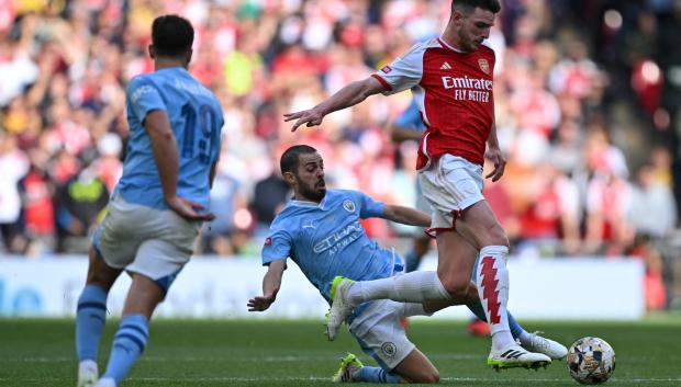 Declan Rice (R) pelea un balón con Bernardo Silva en la final de la Community Shield