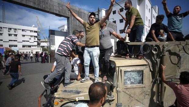 Palestinos sobre un jeep militar israelí por las calles de Gaza.