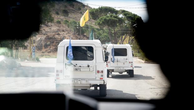 Un vehículo de UNIFIL pasa por una rotonda con la bandera amarilla de Hezbolá