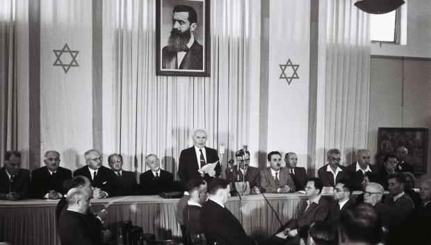 Ben Gurión proclama el Estado de Israel, en un museo de Tel Aviv, bajo el retrato de Theodor Herzl (14 de mayo de 1948)