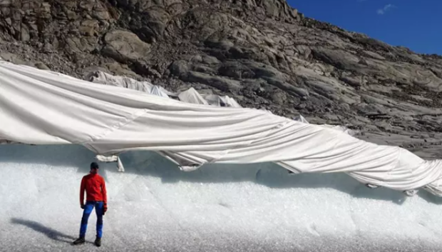 Un investigador frente al glaciar Ródano cubierto de geotextiles