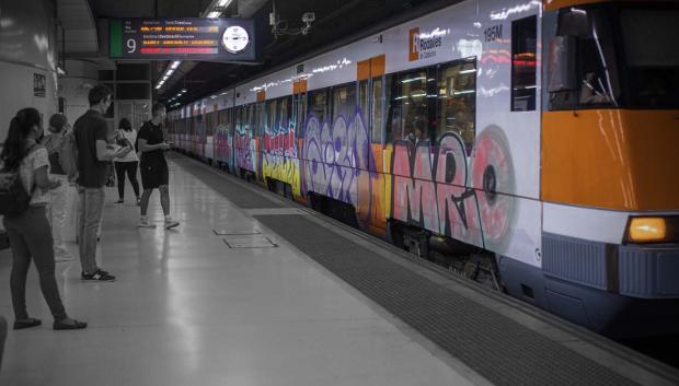 Viajeros esperan la llegada de un tren en uno de los andenes de la estación de Sants