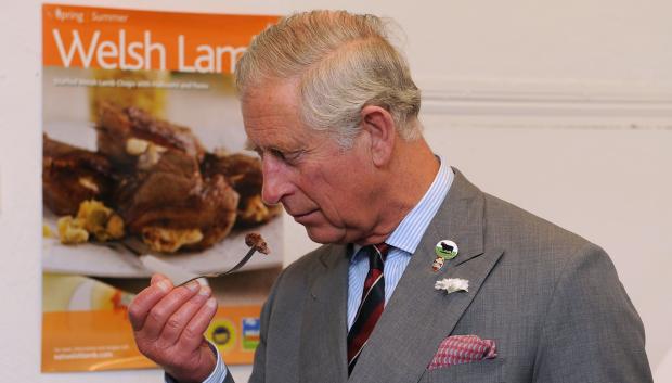 The Prince of Wales samples a beef burger made with locally farmed Welsh Black beef during a visit to the Cig Mynydd Cymru Farmers' Co-operative Shop, Treharris.
En la foto oliendo un trozo de carne