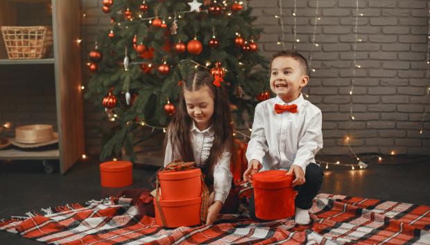 Niños abriendo sus regalos de Navidad