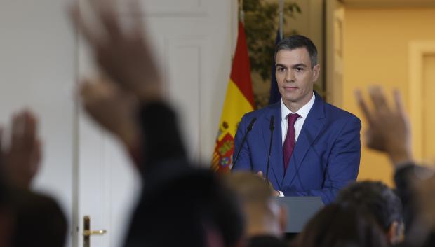 Pedro Sánchez mira las manos levantadas de los periodistas