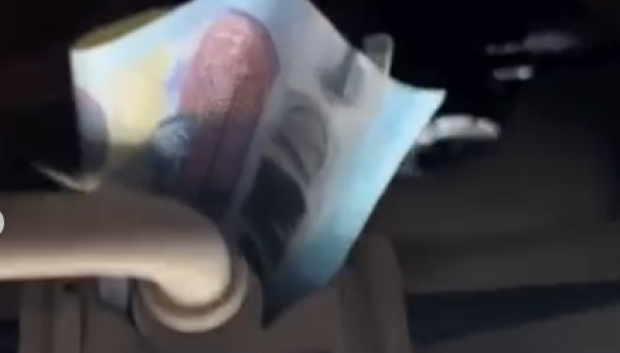 Un billete de 20 euros estratégicamente colocado en la dirección del coche